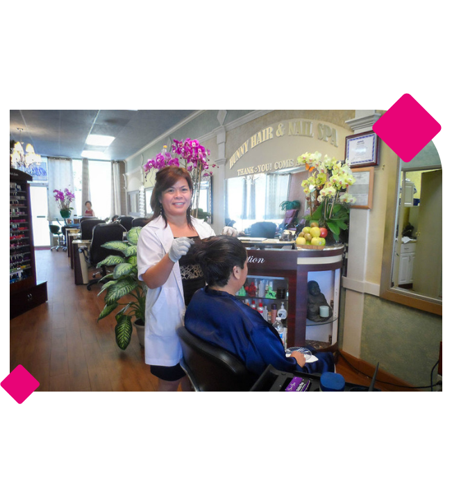 A woman smiling and getting ready to treat her clients hair