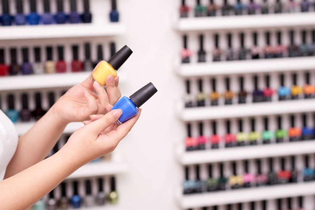 A salon counter displays various vibrant nail polish bottles